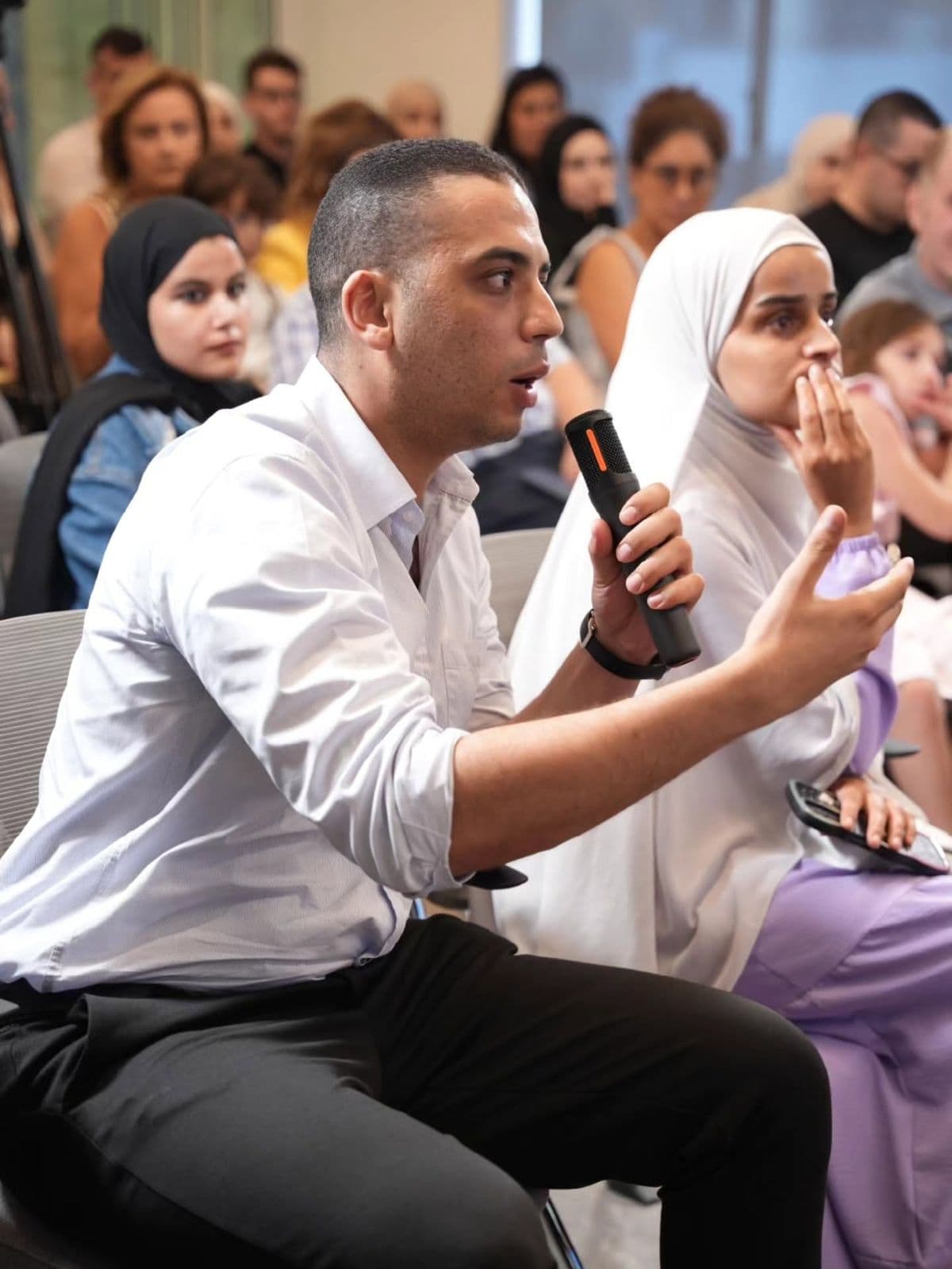 A man in the audience asks a question into a microphone during JadwaTalks