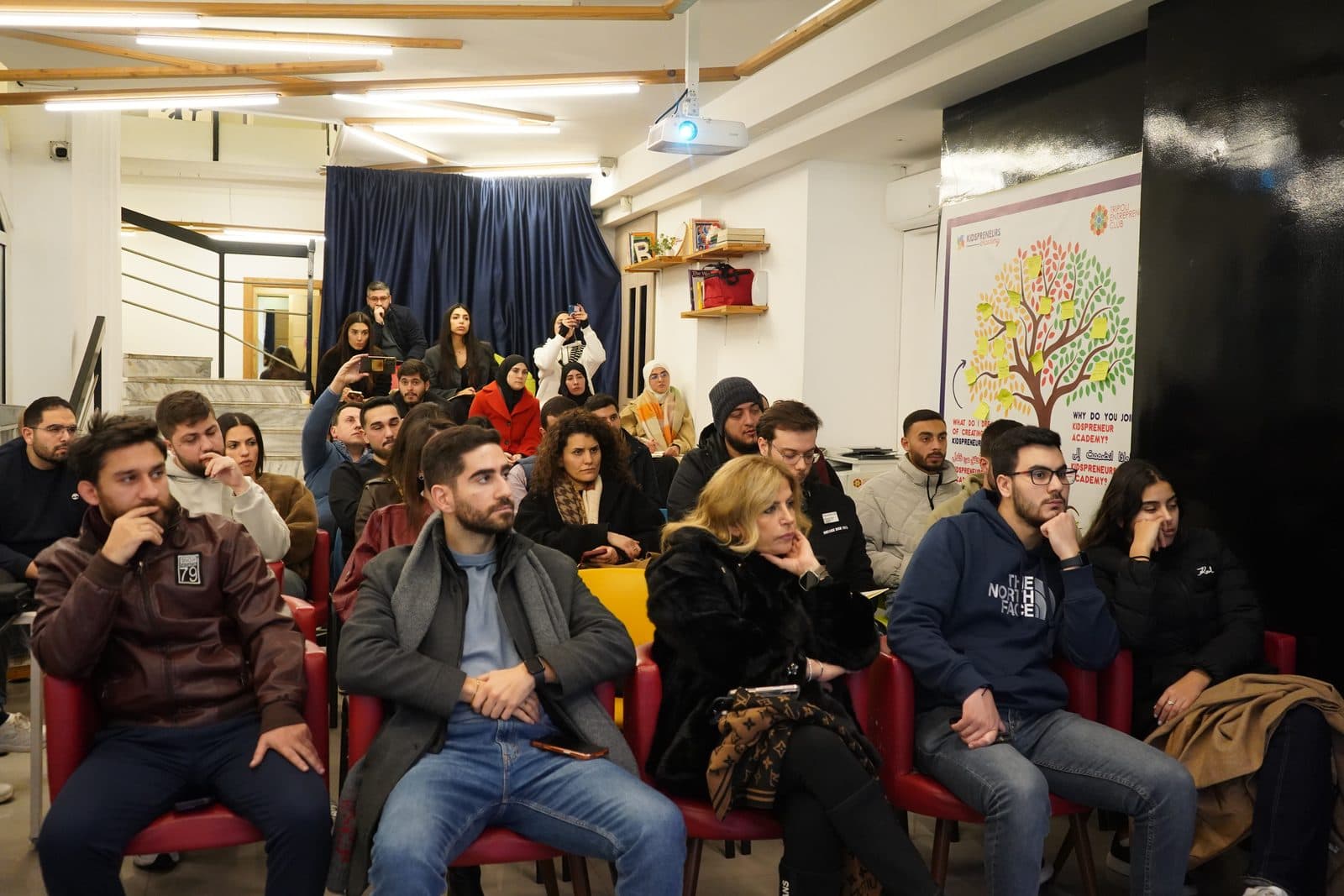 A full room of participants follows a training session