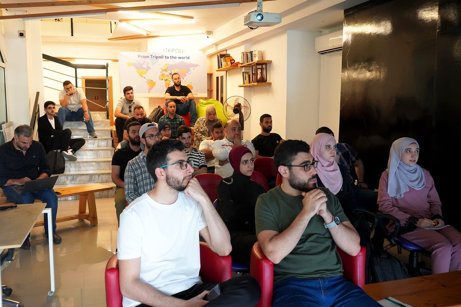 Participants seated in a training room listen to a session