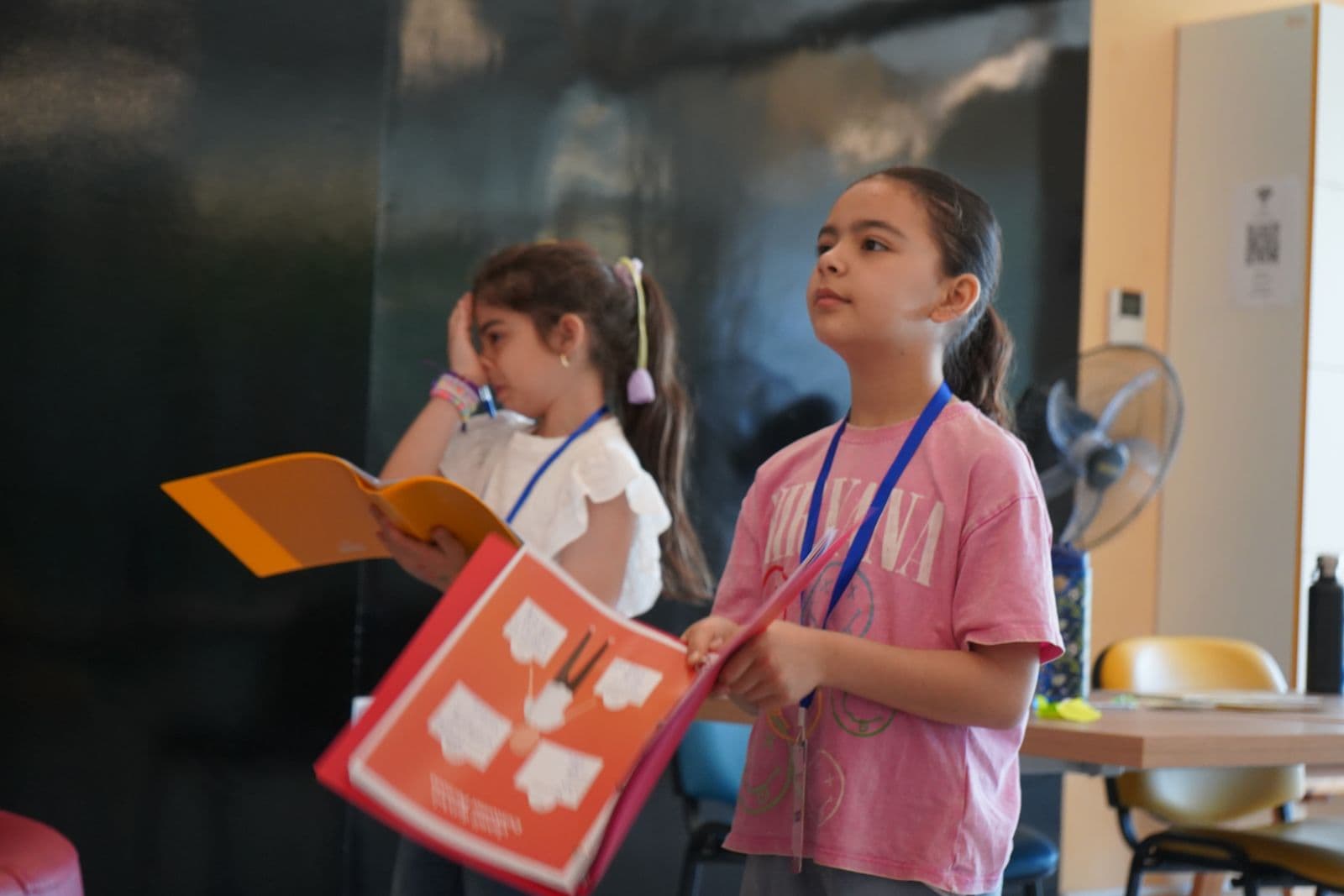 Two girls standing and presenting a worksheet to the group at Youngpreneurs Academy