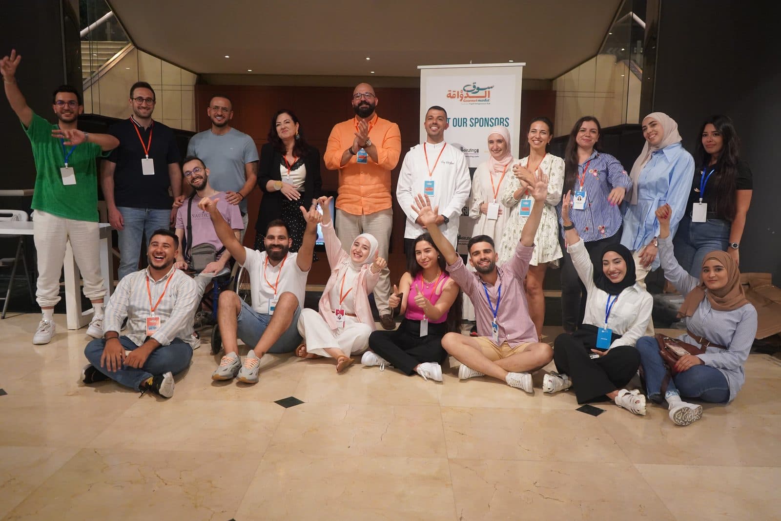 The Gourmet Market team and volunteers cheer together in a group photo