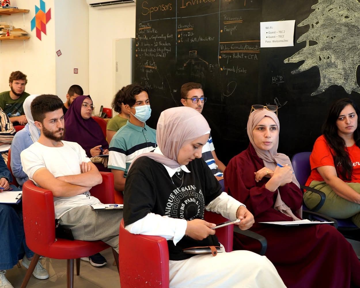 Participants seated in rows follow a workshop and take notes