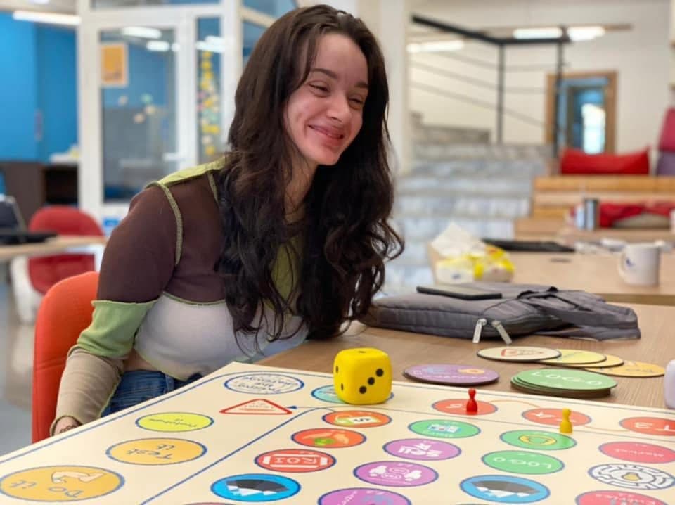 A founder smiles during a board game workshop on business decisions