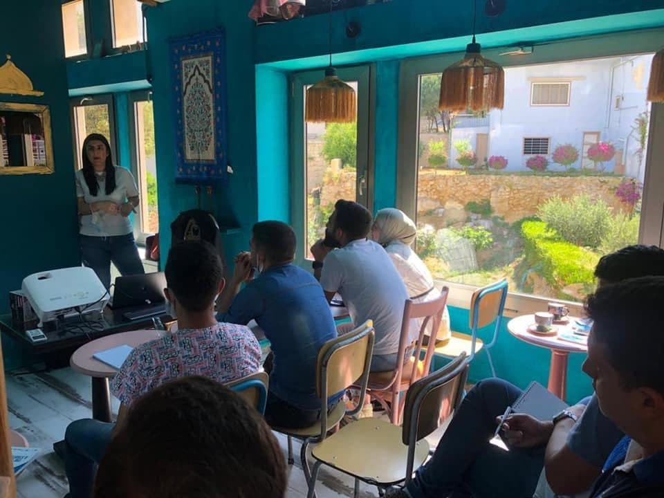Business owners follow a session next to large garden windows