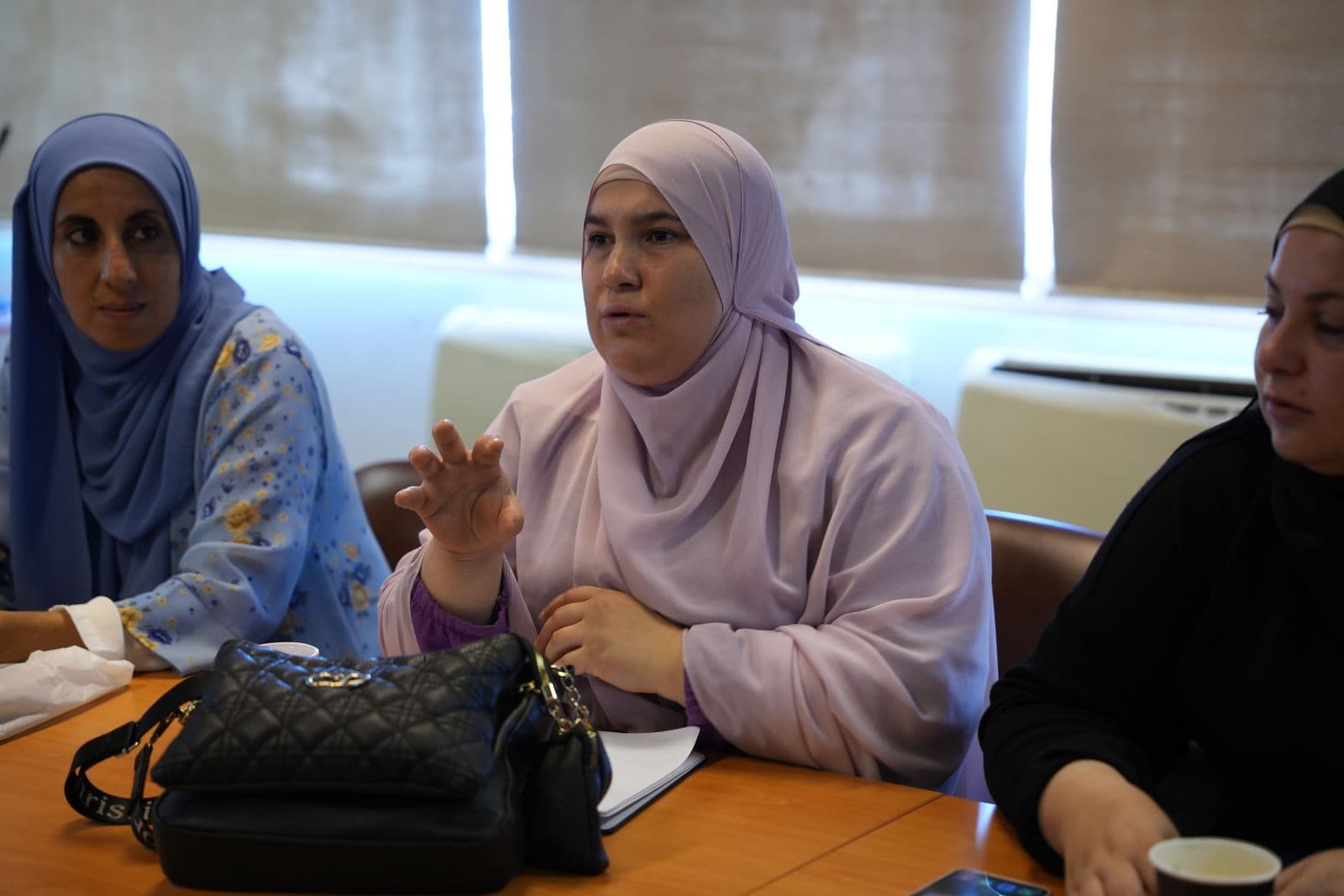 Women participants discuss around a table during a Haretna training session