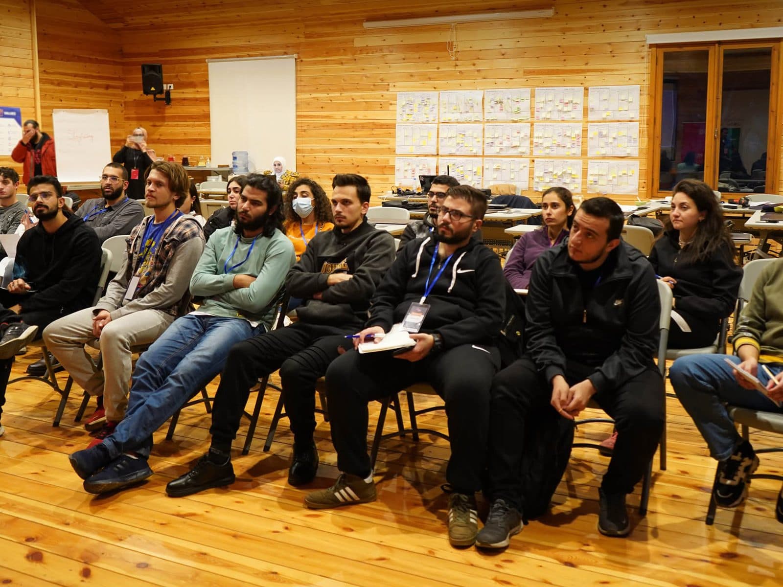 Bootcamp participants seated in rows in a wooden training hall
