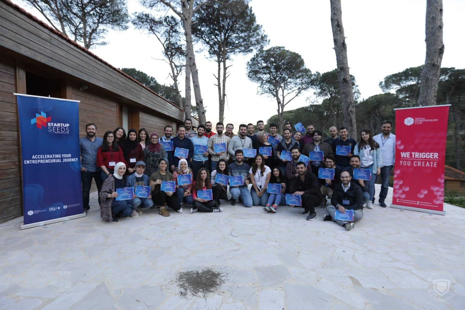 The Startup Seeds cohort poses outdoors between program banners