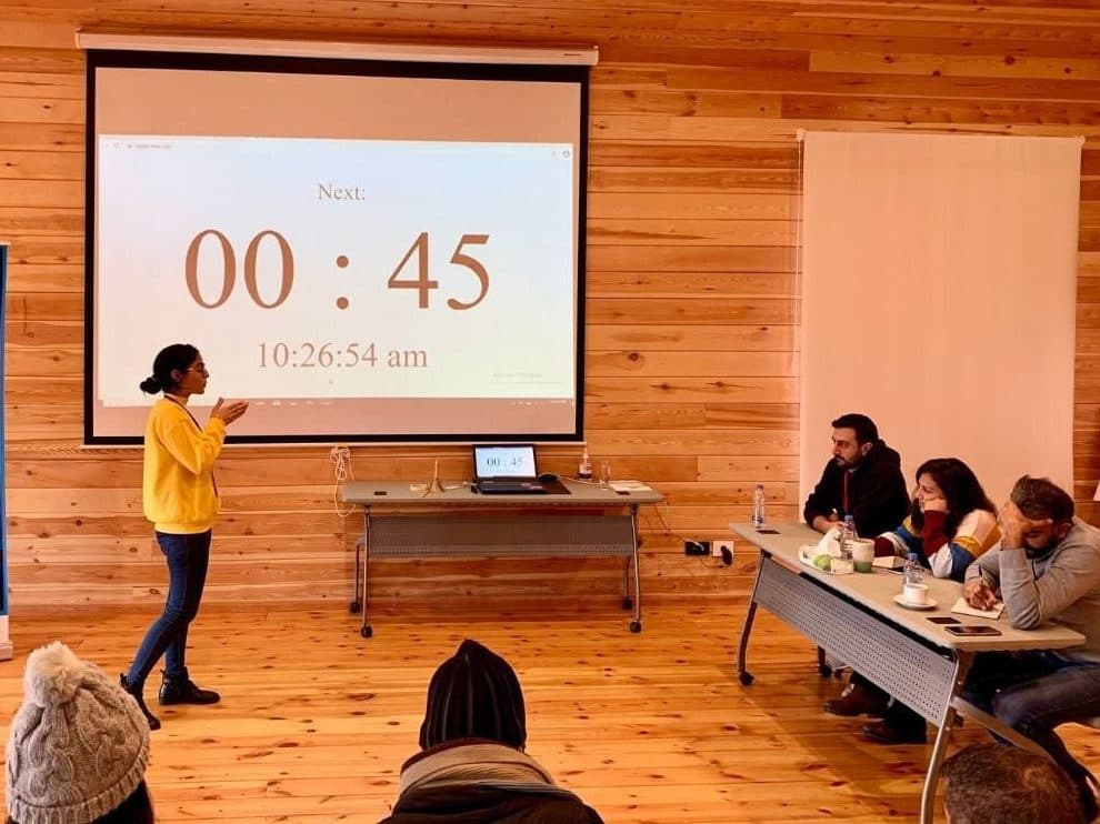 A founder pitches to the jury with a countdown timer on the screen behind her